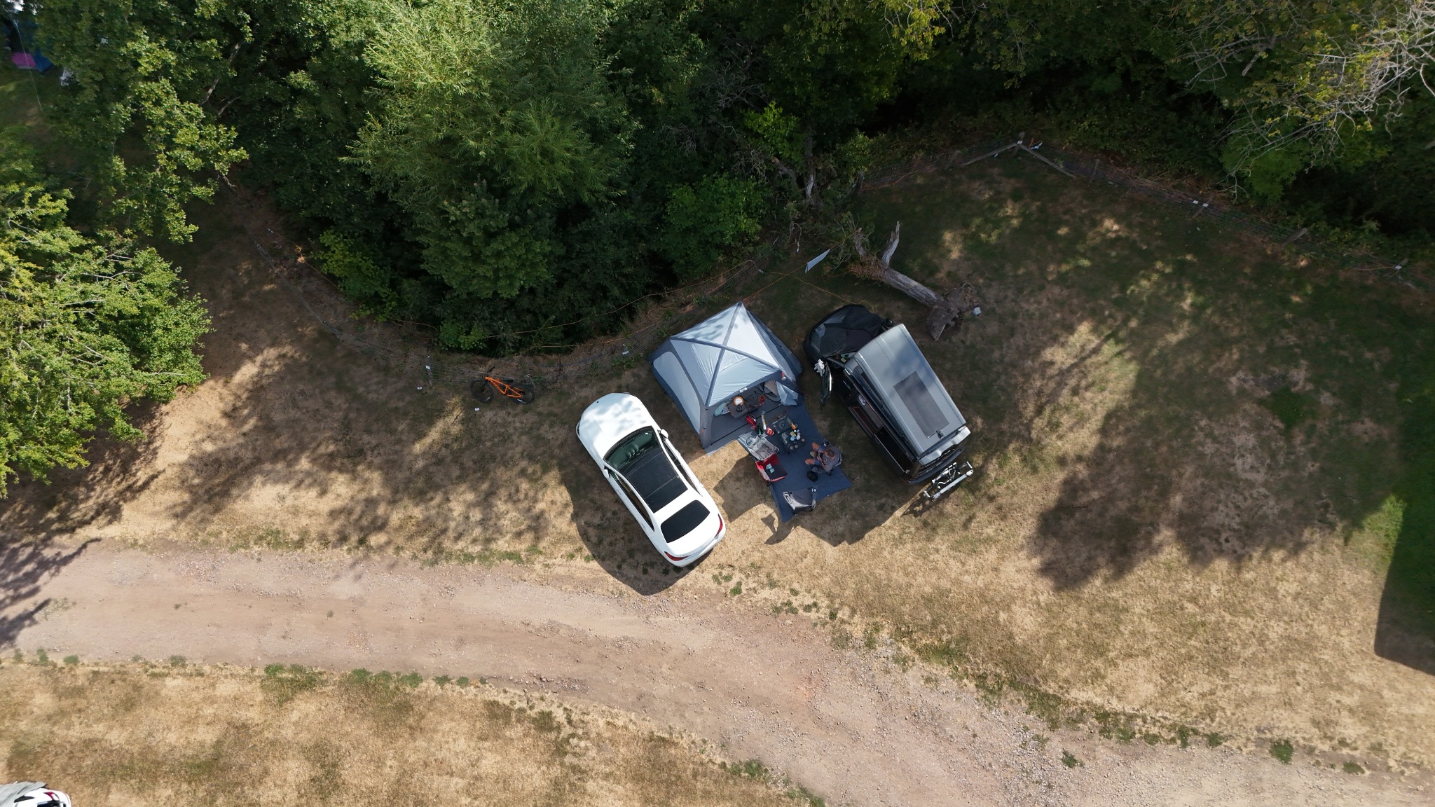 Straight-down aerial photograph of the NIX campervan camp beneath mature trees