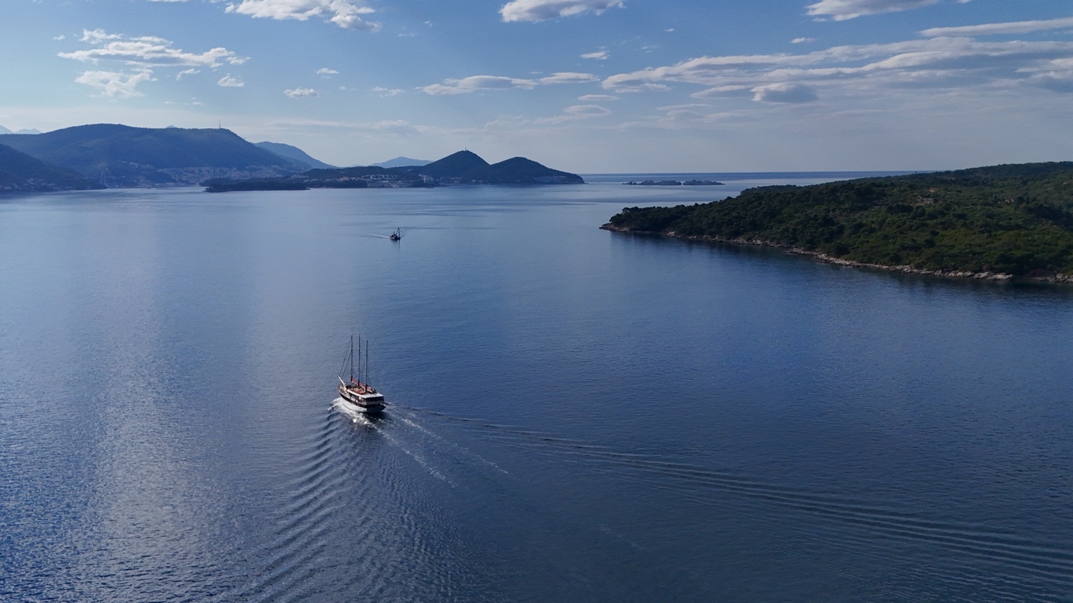 Aerial drone photograph of a small boat on clear blue water near Dubrovnik