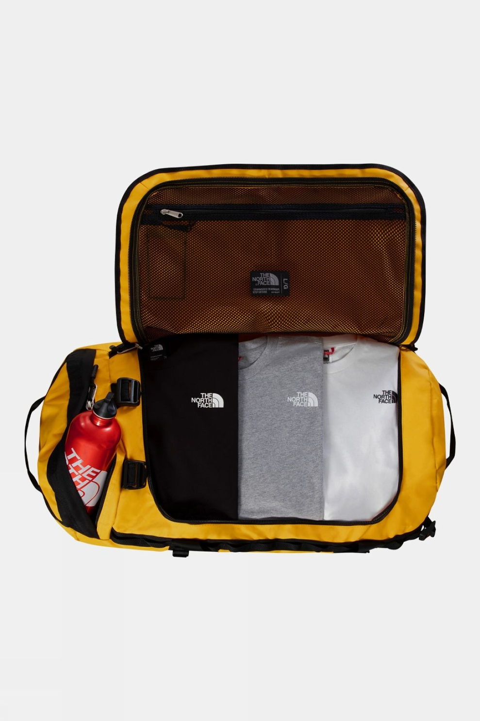 Summit Gold The North Face Base Camp Duffel Large opened wide with folded clothing and a bottle packed inside