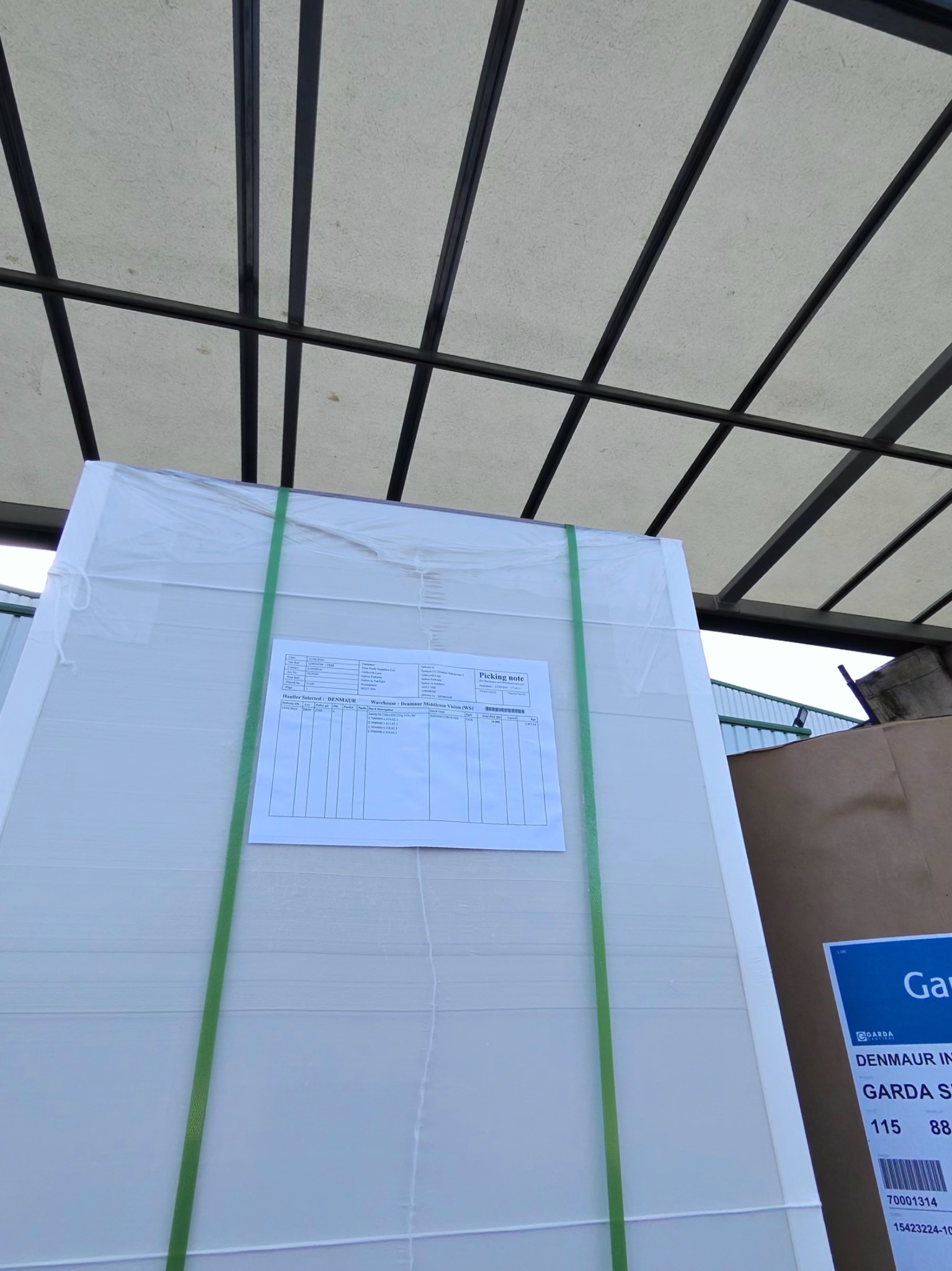 Close view of a tall wrapped paper pallet beneath the curtainsider roof